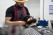 © Cavan Images - The hands of young barber making the cut of beard