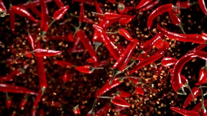 Poster - Super slow motion of flying red hot chilli peppers isolated on black background. Overhead view, filmed on high speed cinema camera, 1000 fps. Ultimate perspective of flying food. Speed ramp effect.