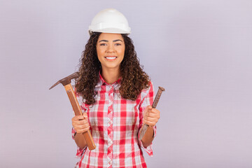 Contractor woman holding a hammer and cleaver.