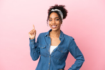 Sticker - Young latin woman isolated on pink background showing and lifting a finger in sign of the best