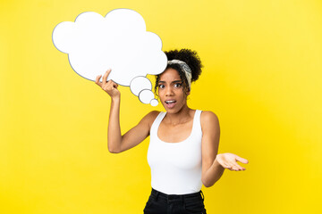 Canvas Print - Young african american woman isolated on yellow background holding a thinking speech bubble and with sad expression