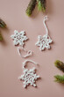 Sustainable and eco-friendly Christmas deco, handmade crochet cotton snowflakes, flatlay on beige