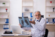 © Elnur - Old male doctor radiologist working in the clinic