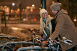 © luckybusiness - Happy man and woman ride bike at snowy night