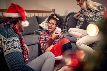 Wall Mural -  girl with gift celebrating christmas with  friends