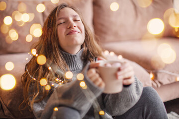 Wall Mural - Young woman enjoys a cup of coffee or cocoa