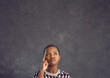 © Studio Romantic - Studio portrait of serious confused undecided curious beautiful black woman isolated on copyspace background looking up, thinking and doubting trying to make hard choice or answer difficult question