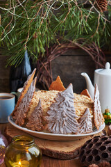 Sticker - Napoleon cake decorated with Christmas gingerbread cookies. Fir branches, cones, candles, coffee, side view, wooden background.