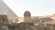 Egyptian Sphinx against the background of the ancient pyramids in Giza