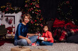 © dmitriisimakov - little curly girl and mother at the Christmas tree with gifts new year lights garland