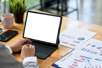 Close up of Woman hand using computer tablet blank white screen on office desk.