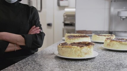 Wall Mural - Close up of an unrecognizable pastry chef posing near of cheese cakes at confectionery. High quality FullHD footage