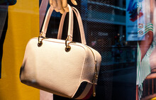 Shop Window.women's Bag In The Hand Of A Mannequin. Beige Ladies Handbag  Quite Classy And Elegant Look A Must For Women's Wardrobe, Fashion Concept.