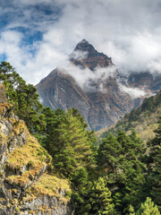 Wall Mural - view from valley to triangle summit in clouds in sunny day in nepal