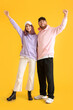 © Pixel-Shot - Cool happy young couple in hoodies on color background