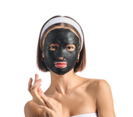 Wall Mural - Young woman with activated charcoal mask on her face against white background