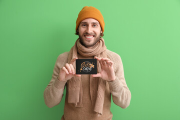 Poster - Young man with gift card on color background