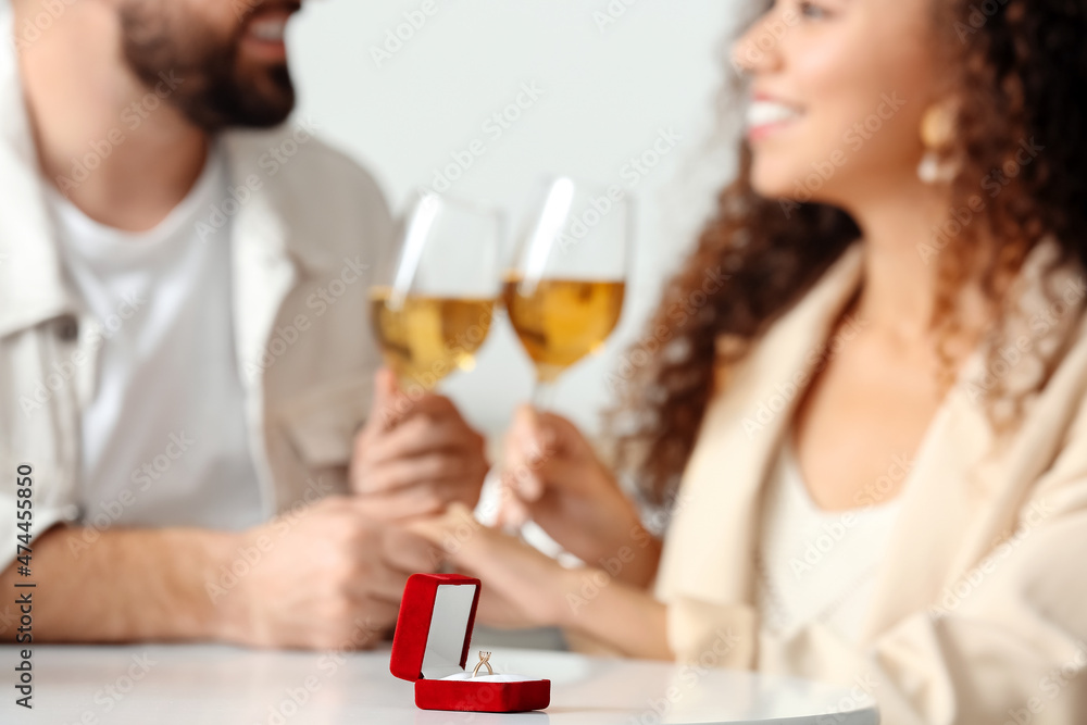 Box with engagement ring on table of young couple. Marriage proposal concept