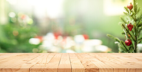 Selective focus.Empty wood table top with blur abstract light bokeh of christmas tree,decoration background