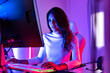 © anon - young  playing game online at home. Gamer  controlling joystick for video game. Teenage girls leisure game in neon light room at home.