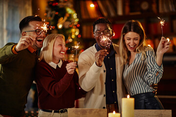 Multiracial friends with sparkles at Christmas night