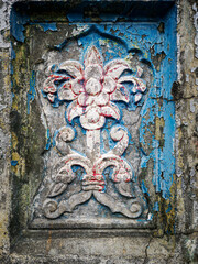 texture of the relief of the wall of an old building, lily flower cracked and chipped vintage detail of an architectural element