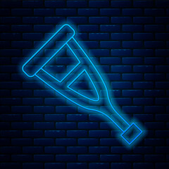 Sticker - Glowing neon line Crutch or crutches icon isolated on brick wall background. Equipment for rehabilitation of people with diseases of musculoskeletal system. Vector