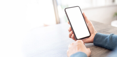 cell phone blank white screen mockup.hand holding texting using mobile on desk at office.background 