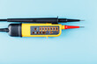 Yellow tester for step-by-step indication of voltage in an electrical circuit on a blue background.