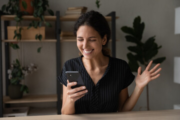 Wall Mural - Excited young Latin woman feel euphoric win online lottery on smartphone. Smiling Hispanic female triumph read good news, get unexpected promotion deal or sale discount on cellphone. Luck concept.