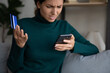 Unhappy Latin woman shopping online on cellphone have problems with credit debit card paying. Upset confused Hispanic female buyer frustrate with debt or bankruptcy make payment on internet on cell.