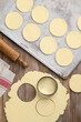 Rolled out shortbread dough. Cutting out cookies.   Shortcrust pastry.  Round unbaked biscuits. Culinary baking  concept. Top view