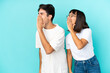 © luismolinero - Young mixed race couple isolated on blue background shouting with mouth wide open to the lateral