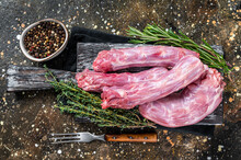 Raw Turkey Or Chicken Necks Meat On A Wooden Board With Thyme. Brown Background. Top View