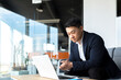 © Liubomir - Portrait thoughtful Asian businessman working on a laptop computer at a modern office desk. Confident Focused pensive man in formal suit indoors. thinking of inspiration solving a problem. Startup