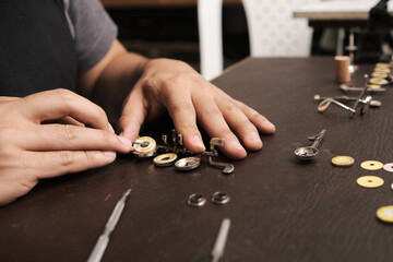 close-up of instrument repairman removing old pads from flute keys