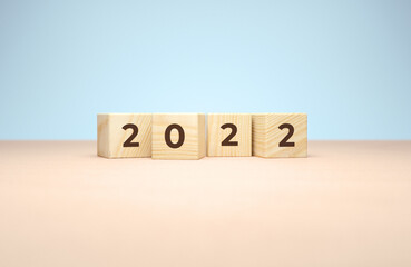 Wall Mural - New year 2022 wooden cubes in 3d rendering on a minimal background. Holiday illustration for poster or greeting card design concept in realistic 3D rendering