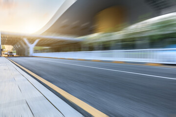 Motion blurred asphalt road and modern commercial building landscape