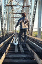Man With An Electric Guitar In The Industrial Landscape Outdoors
