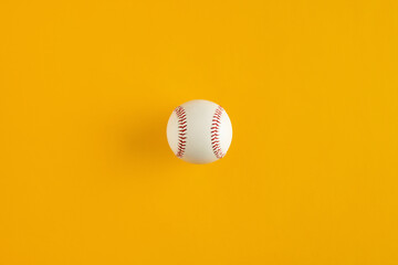 Wall Mural - Baseball ball on yellow background with copy space.