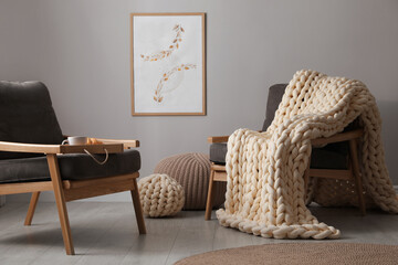 Sticker - Soft chunky knit blanket on armchair in room. Interior design