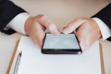 Businesswoman Text Messaging Through Smart Phone At Office