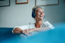 Happy Woman Listening Music Through Headphones At Home
