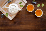 Fototapeta Mapy - Tea drinking with white teapot and two cups with green leaves, top view