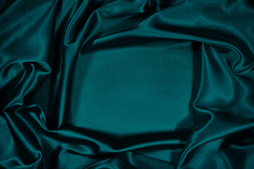 Wall Mural - Green silk satin velvet. Wavy soft folds. Smooth. Shiny fabric. Luxurious dark teal background with copy space for design. Table top view. Flat lay. Empty. Template.