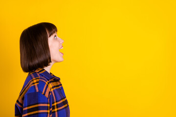 Wall Mural - Profile side view portrait of attractive cheerful amazed girl looking copy space ad isolated over bright yellow color background