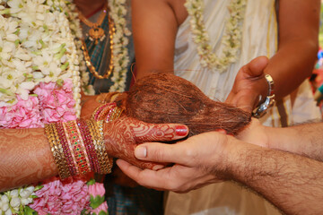 A Close up picture of Hands of the Bride and the Groom during their Hindu wedding ritual performed according to the South Indian tradition in India.
