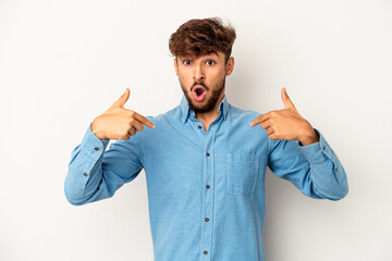 Wall Mural - Young mixed race man isolated on grey background points down with fingers, positive feeling.