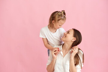 Wall Mural - lovely beautiful young mother and little daughter hug and look at each other. photo in the studio. c