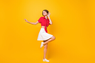 Poster - Full body portrait of adorable carefree person look empty space raise knee toothy smile isolated on yellow color background